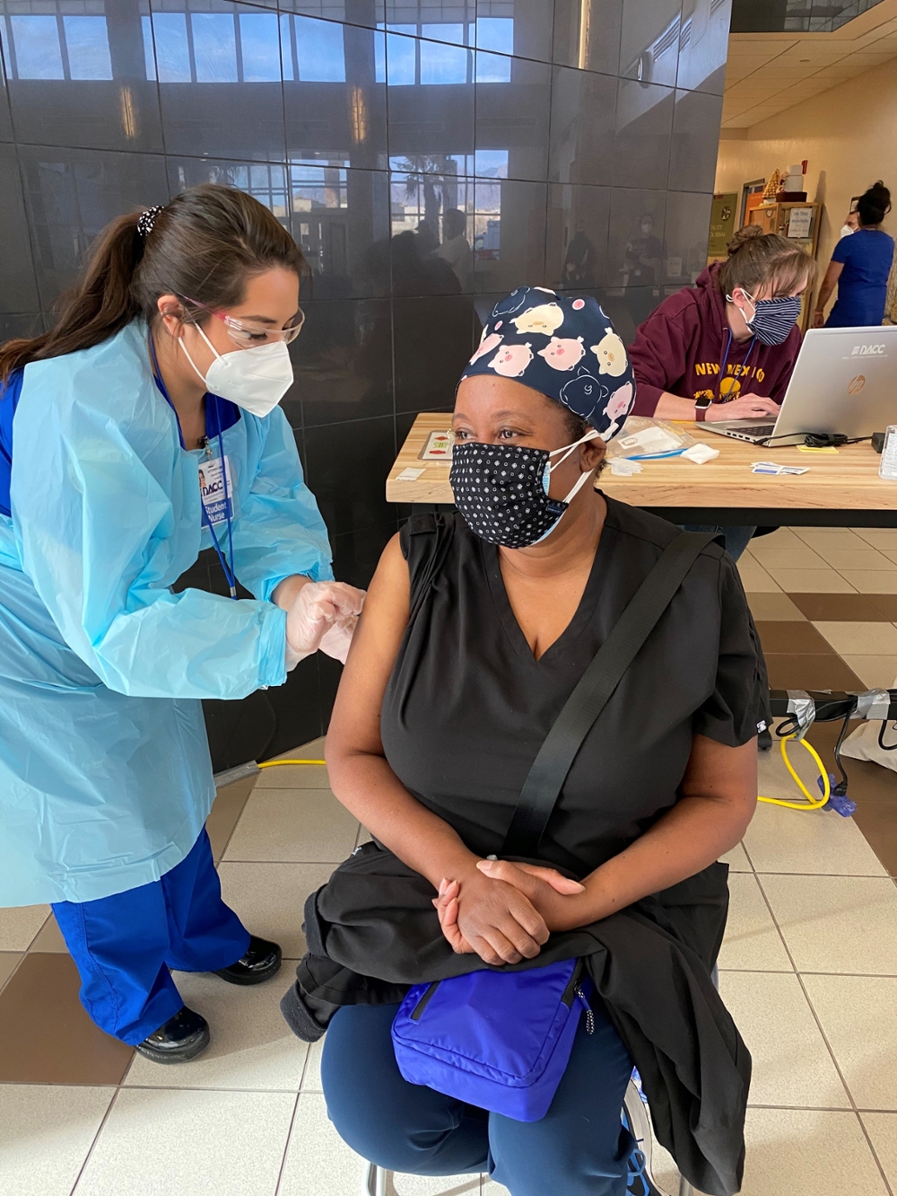 A DACC student nurse swabs her patient's right arm, preparing her for a shot.